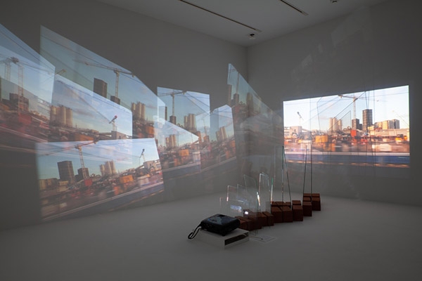 Return Journey, 2023, single video projection installation with 10 sheet glass, Kaz